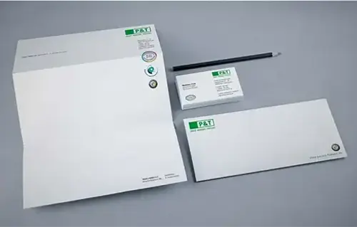 Ein Brief, ein Briefumschlag, ein Bleistift und eine Taschentuchpackung mit dem Logo von P&T.
